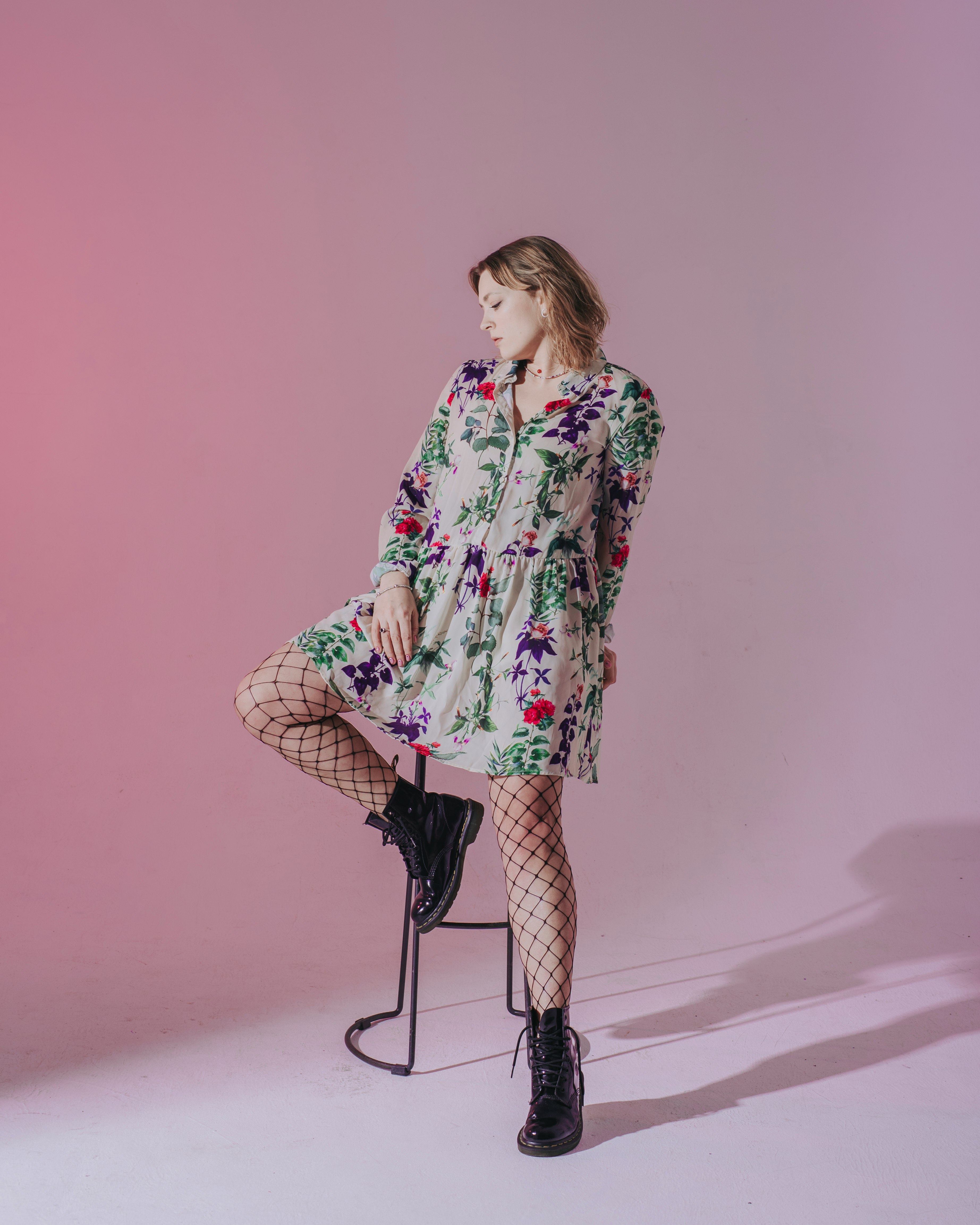 woman in white red and green floral long sleeve shirt standing